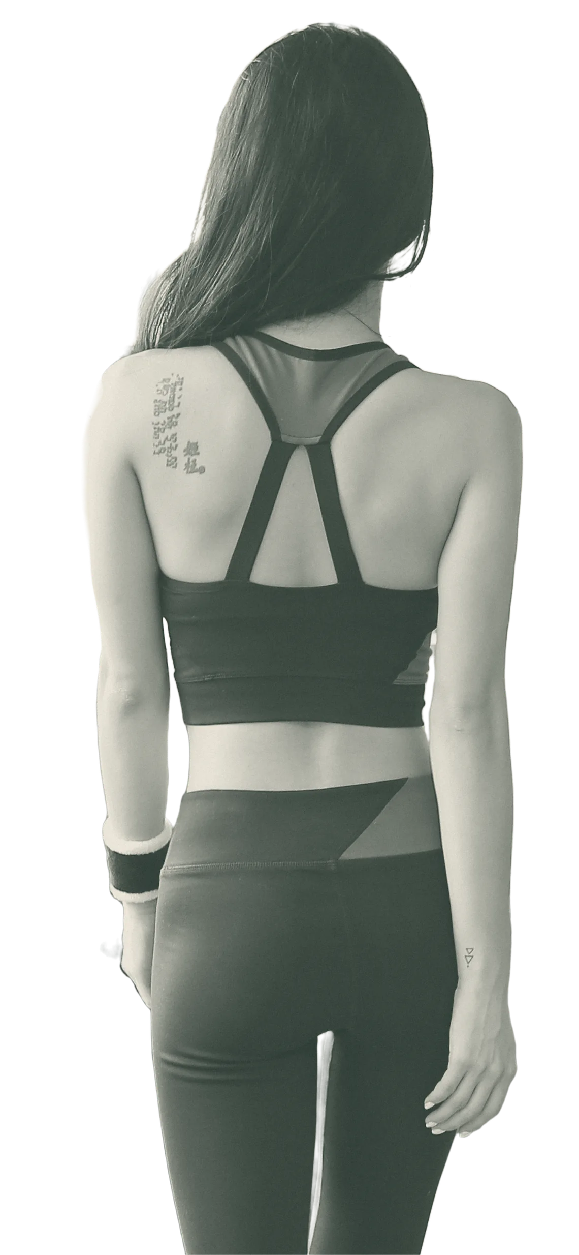 A woman photographed from behind, walking, in active wear.